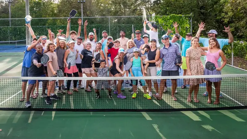 Groupe de joueurs souriants après une session de pickleball à Genève