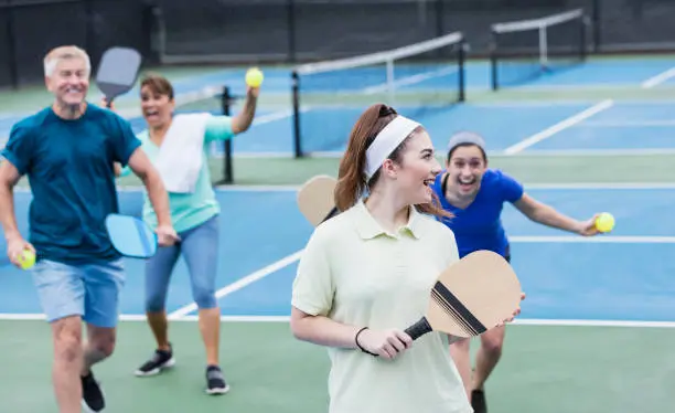 Joueur frappant une balle de pickleball lors d'une session indoor à Genève